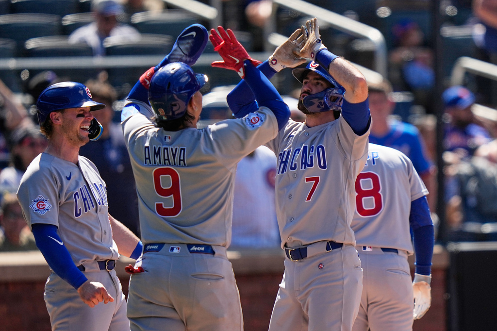 Chicago Cubs' Dansby Swanson (7) celebrates with Miguel Amaya (9), Ian Happ (8) and Nico Hoerner after hitting a grand slam during the eighth inning of a baseball game against the New York Mets Wednesday, June 24, 2026, in New York. (AP Photo/Frank Franklin II)
