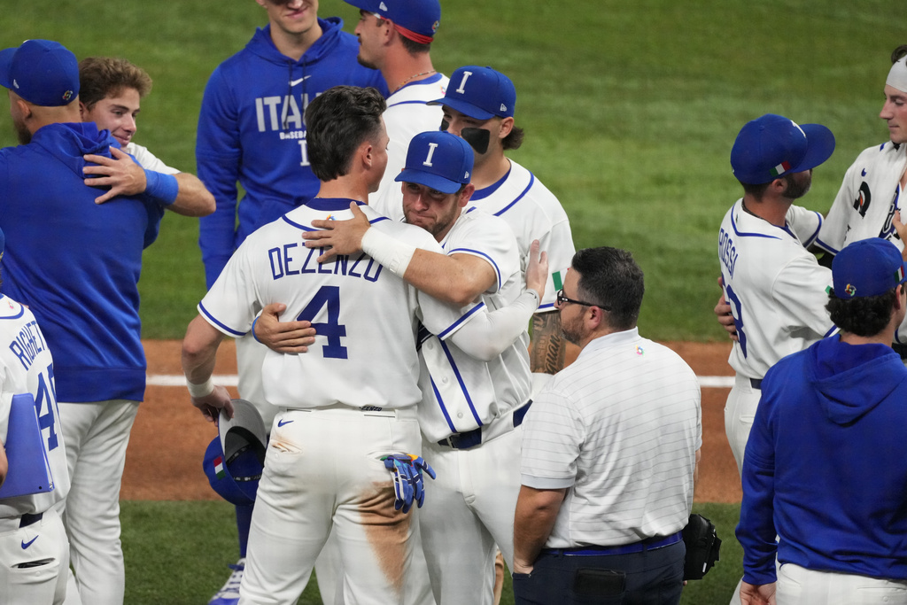 The Italy team console each other after losing to Venezuela at a World Baseball Classic semifinal game, Monday, March 16, 2026, in Miami. (AP Photo/Lynne Sladky)