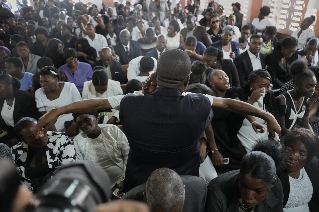Relatives attend the funeral of four victims of a gang attack in the Kenscoff neighborhood of Port-au-Prince, Haiti, Sunday, Aug. 30, 2026. (AP Photo/Odelyn Joseph)