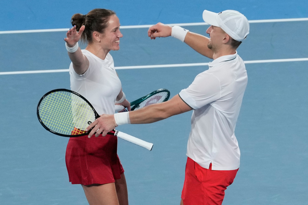 Katarzyna Kawa, left, and Jan Zielinski of Poland celebrate after defeating Belinda Bencic and Jakub Paul of Switzerland in the doubles final match at the United Cup tennis tournament in Sydney, Sunday, Jan. 11, 2026. (AP Photo/Rick Rycroft)
