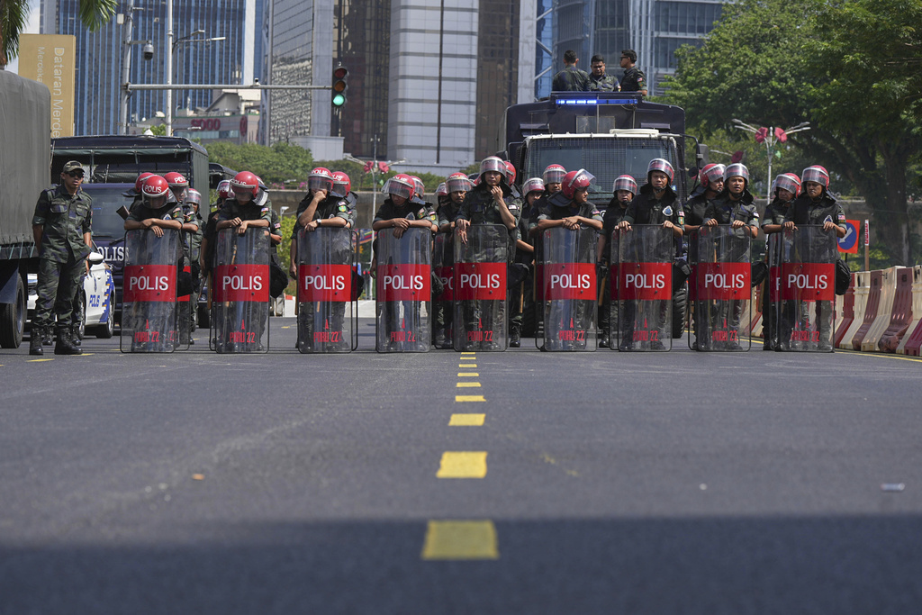 Federal Reserve Unit (FRU) police officers block a road during a demonstration against U.S. President Donald Trump's attendance at the Association of Southeast Asian Nations (ASEAN) Summit in Kuala Lumpur, Malaysia, on Sunday, Oct. 26, 2025. (AP Photo/Azneal Ishak)