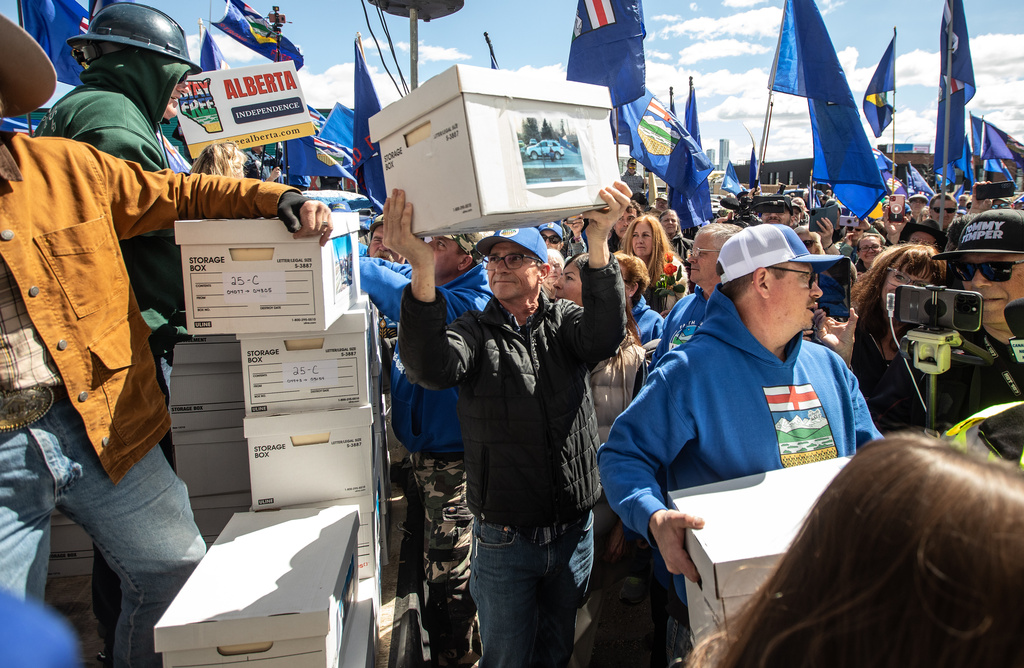 Supporters carry boxes of signatures to submit for a separation referendum to Elections Alberta in Edmonton, on Monday, May 4, 2026. (Jason Franson/The Canadian Press via AP)
