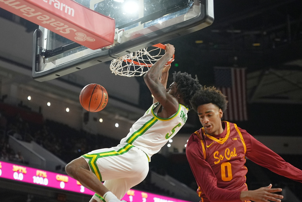 Oregon guard Takai Simpkins (5) scores against Southern California guard Takai Simpkins (0) during the first half of an NCAA college basketball game Saturday, Feb. 21, 2026, in Los Angeles. (AP Photo/Damian Dovarganes)