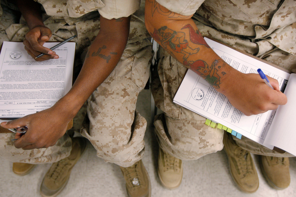 FILE - U.S. Marines fill out research consent forms before taking psychological tests at the Marine Corps Air Ground Combat Center in Twentynine Palms, Calif., on Sept. 29, 2009. (AP Photo/Jae C. Hong, File)