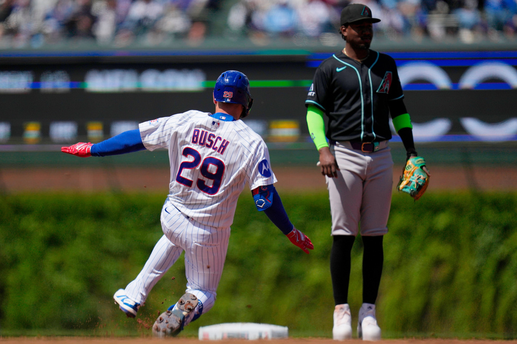 Chicago Cubs' Michael Busch (29) slides safely into second for a double as Arizona Diamondbacks shortstop Geraldo Perdomo (2) looks on during the third inning of a baseball game Saturday, May 2, 2026, in Chicago. (AP Photo/Erin Hooley)