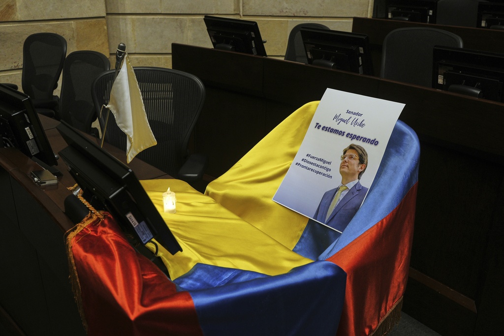 FILE - A leaflet showing Colombian Sen. Miguel Uribe Turbay sits on a Colombian national flag draped over his seat in the congressional chamber in Bogota, Colombia, June 9, 2025. (AP Photo/Ivan Valencia, File)