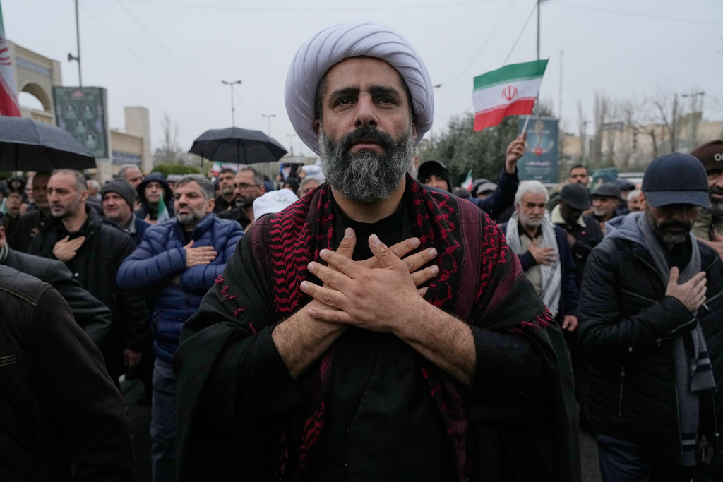 A cleric beats his chest as he mourns during the funeral procession of Iran's intelligence minister Esmail Khatib and, according to Iranian officials, his wife and daughter, in Tehran, Iran, Friday, March 20, 2026. (AP Photo/Vahid Salemi)
