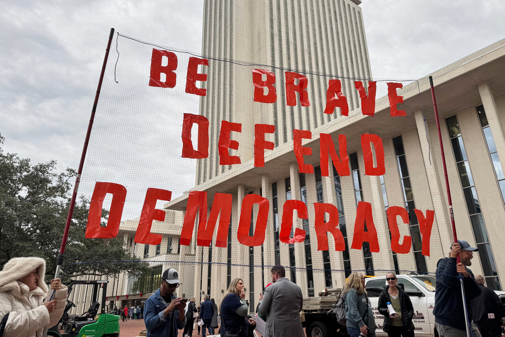 Protestors opposed to mid-decade redistricting hold a sign outside of the Florida Capitol in Tallahassee, Fla. on Dec. 4, 2025. (AP Photo/Kate Payne)