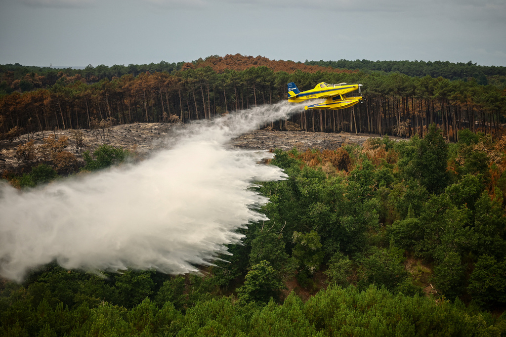 A picture taken from the French Civil Security rescue coordination helicopter shows a firefighting plane dropping water during a wildfire in Le Porge, France, Firday, July 31, 2026. (Sarah Meyssonnier/Pool Photo via AP)