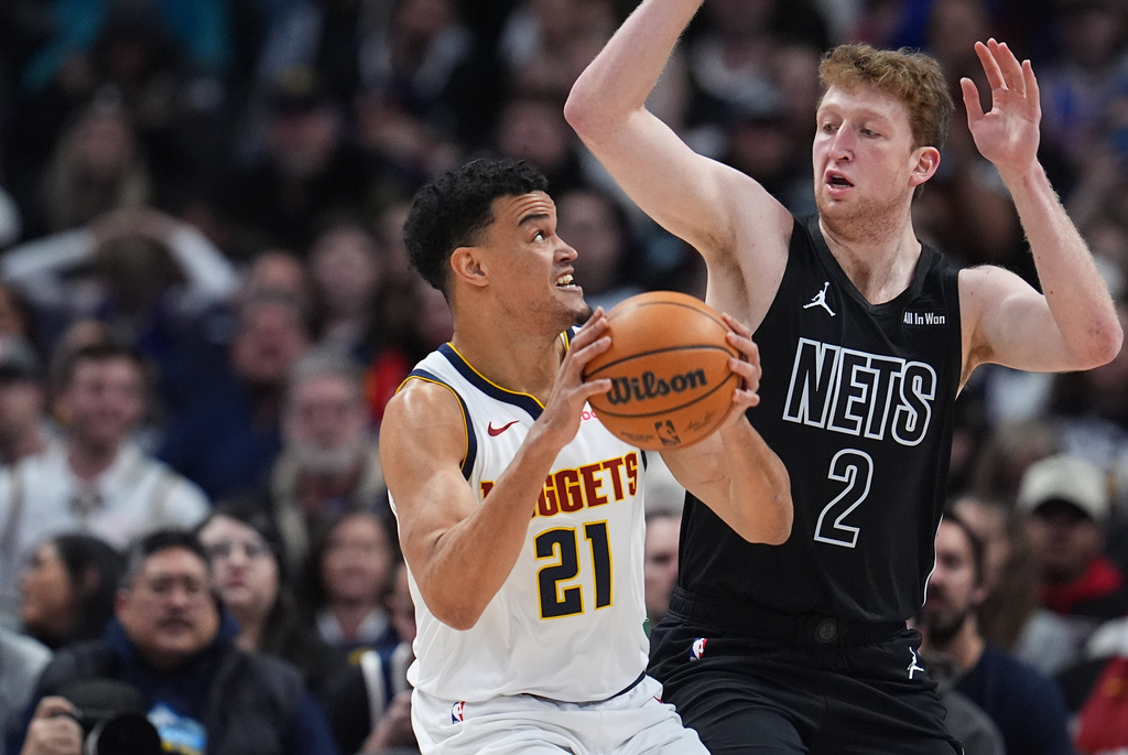 Denver Nuggets forward Spencer Jones, left, goes up for a shot as Brooklyn Nets forward Danny Wolf defends in the first half of an NBA basketball game, Thursday, Jan. 29, 2026, in Denver. (AP Photo/David Zalubowski)