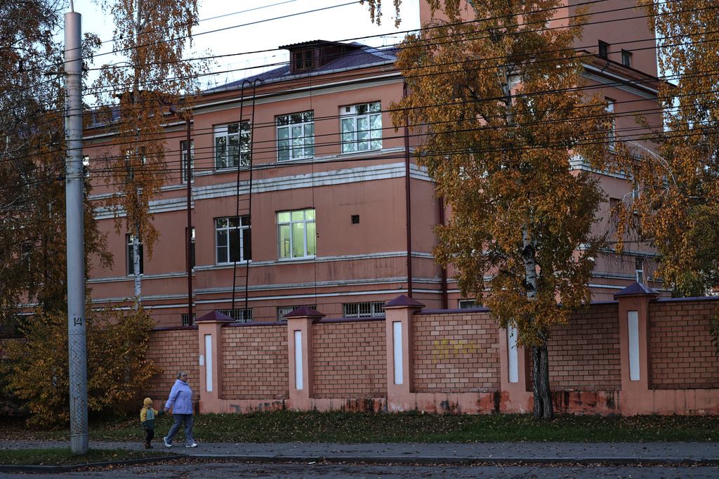 A woman with her child walks past the building of the Irkutsk Anti-Plague Research Institute of Siberia and the Far East in Irkutsk, Russia, on Wednesday, Oct. 7, 2026. (AP Photo)