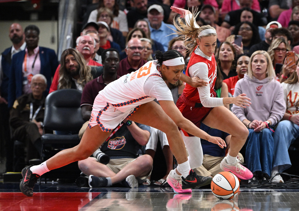 Indiana Fever guard Sophie Cunningham and Connecticut Sun forward Nell Angloma (33) go after a loose ball during the second half of a WNBA basketball game, Friday, Aug. 28, 2026, in Indianapolis. (AP Photo/Marc Lebryk)