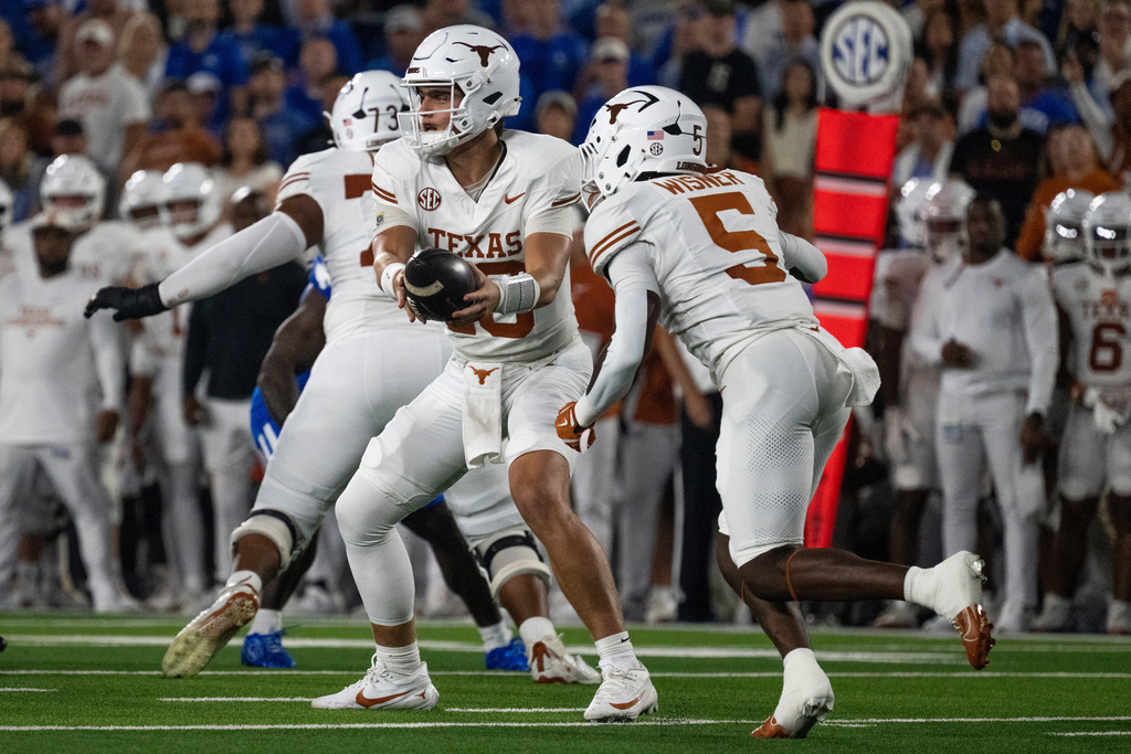 Texas quarterback Arch Manning (16) fakes a hand-off in the first quarter of an NCAA college football game against Kentucky, Saturday, Oct. 18, 2025, in Lexington, Ky. (AP Photo/Michael Swensen)