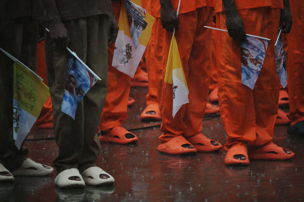 Inmates stand in the rain as they listen to Pope Leo XIV speak during a visit to the prison in Bata, Equatorial Guinea, Wednesday, April 22, 2026, on the final leg of his four-nation African tour. (AP Photo/Andrew Medichini)
