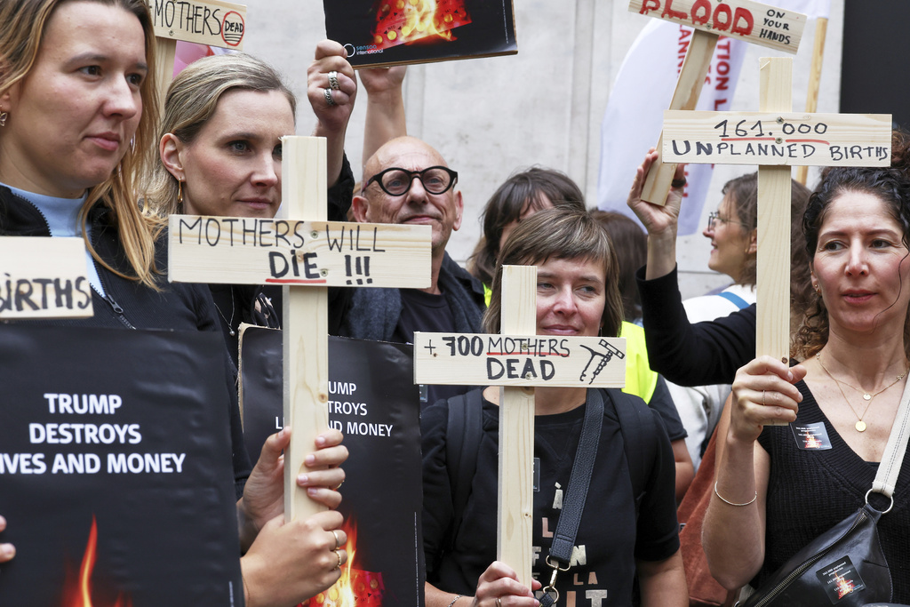Participants from various women's rights organizations hold signs as they demonstrate regarding the destruction of family planning supplies stockpiled in Belgium, near the U.S. embassy in Brussels, Thursday, Sept. 18, 2025. (AP Photo/Omar Havana)