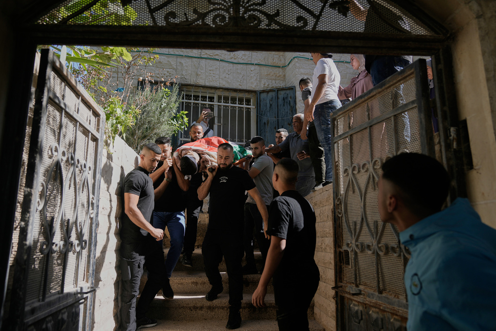 Mourners carry the body of the Palestinian Mohammed Salama, 25, who was killed in an Israeli military raid, during his funeral in the West Bank city of Jenin, Saturday, Oct. 11, 2025. (AP Photo/Majdi Mohammed)