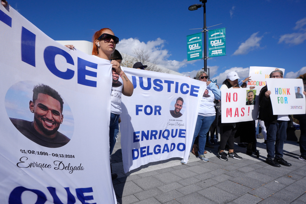 FILE - People display signs with with a likeness of Massachusetts State Police recruit Enrique Delgado-Garcia, who died following a State Police Academy training exercise, at a protest outside the State Police Academy graduation ceremony, Oct. 9, 2024, at the DCU Center, in Worcester, Mass. (AP Photo/Steven Senne, File)