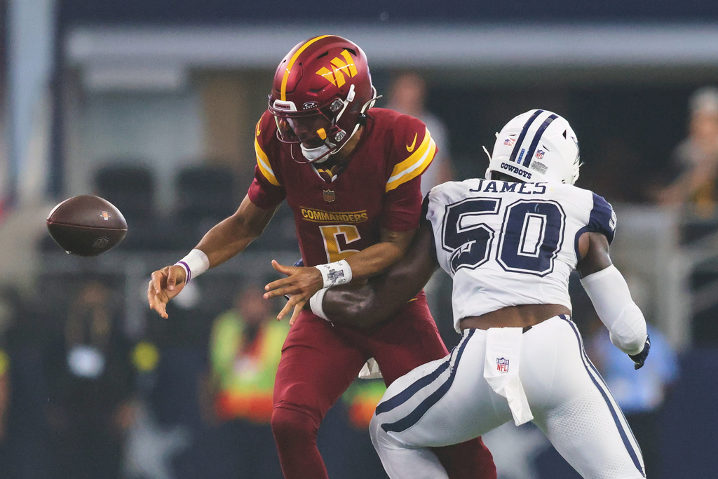 Dallas Cowboys linebacker Shemar James (50) forces a fumble by Washington Commanders quarterback Jayden Daniels (5) during the second half of an NFL football game Sunday, Oct. 19, 2025, in Arlington, Texas. (AP Photo/Gareth Patterson)