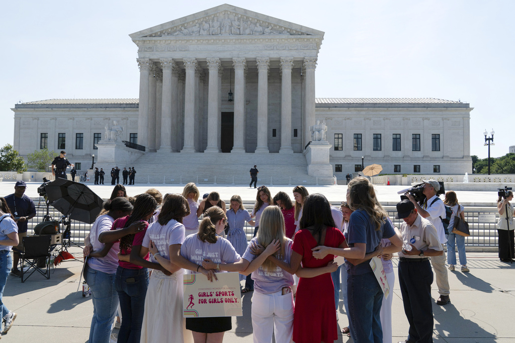 A group prays outside of the Supreme Court ahead of the court's ruling on whether transgender girls and women can play on school athletic teams, Tuesday, June 30, 2026, on Capitol Hill in Washington. (AP Photo/Jose Luis Magana)