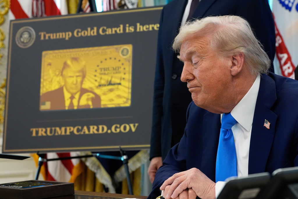 FILE - A poster showing the Trump Gold Card is seen as President Donald Trump signs executive orders in the Oval Office of the White House, Sept. 19, 2025, in Washington. (AP Photo/Alex Brandon, file)