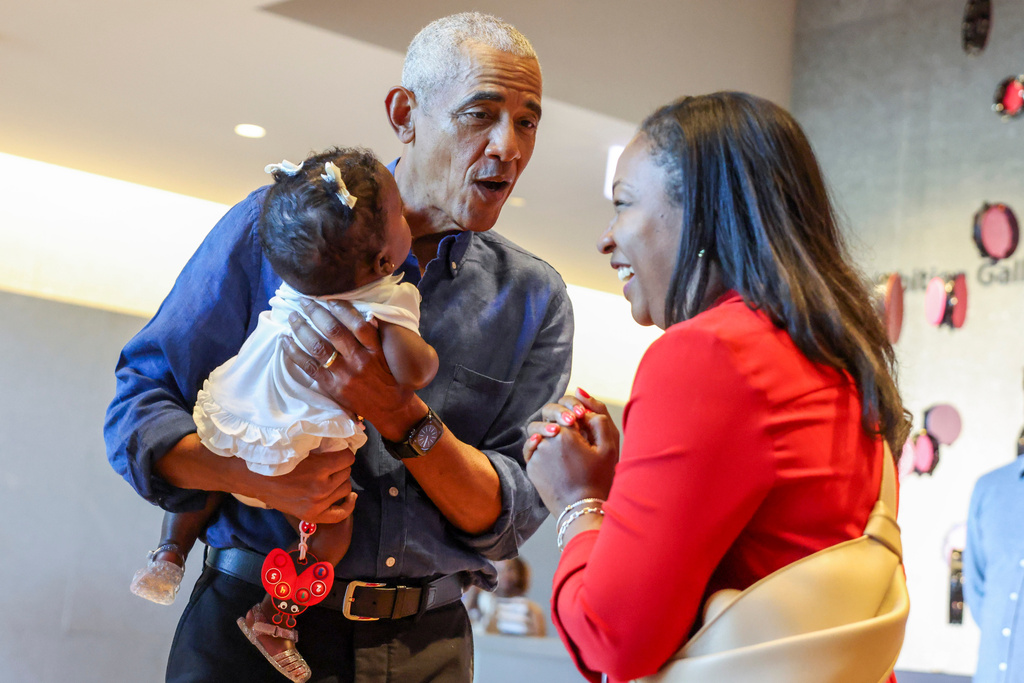Former President Barack Obama holds a baby as he and First Lady Michelle Obama greet community members in the Hope and Change lobby before they walk through the museum at the Obama Presidential Center in Chicago's Jackson Park on Friday, June 19, 2026. (Eileen T. Meslar/Chicago Tribune via AP, Pool)