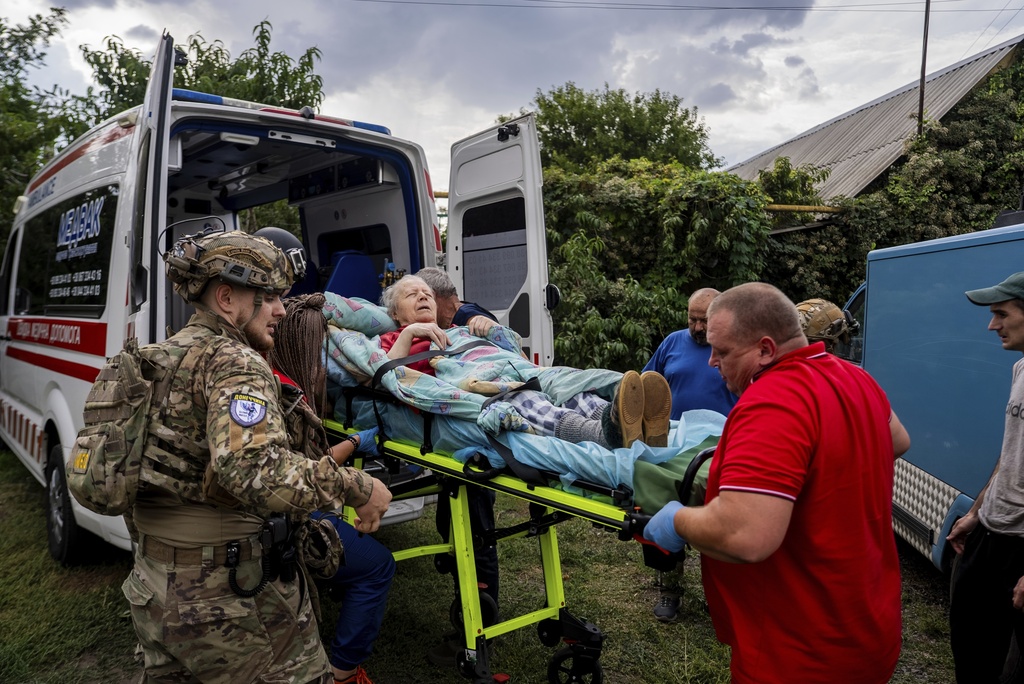 Policemen and medics transfer to the ambulance Olha Trush, 86 from the village of Yarova, that was hit by Russian aerial strike, which killed dozens of civilians, in Sloviansk, Donetsk region, Tuesday, Sept.9, 2025. (AP Photo/Alex Babenko)