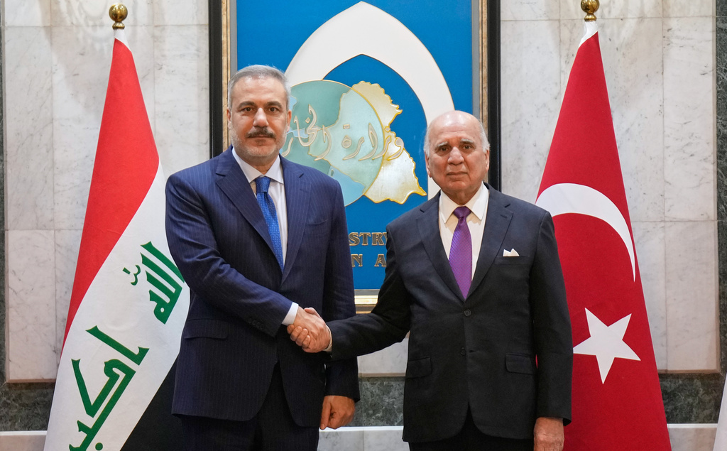 Iraqi Foreign Minister Fuad Hussein, right, shakes hands with Turkish Foreign Minister Hakan Fidan, in Baghdad, Iraq, Sunday, Nov. 2, 2025. (AP Photo/Hadi Mizban)