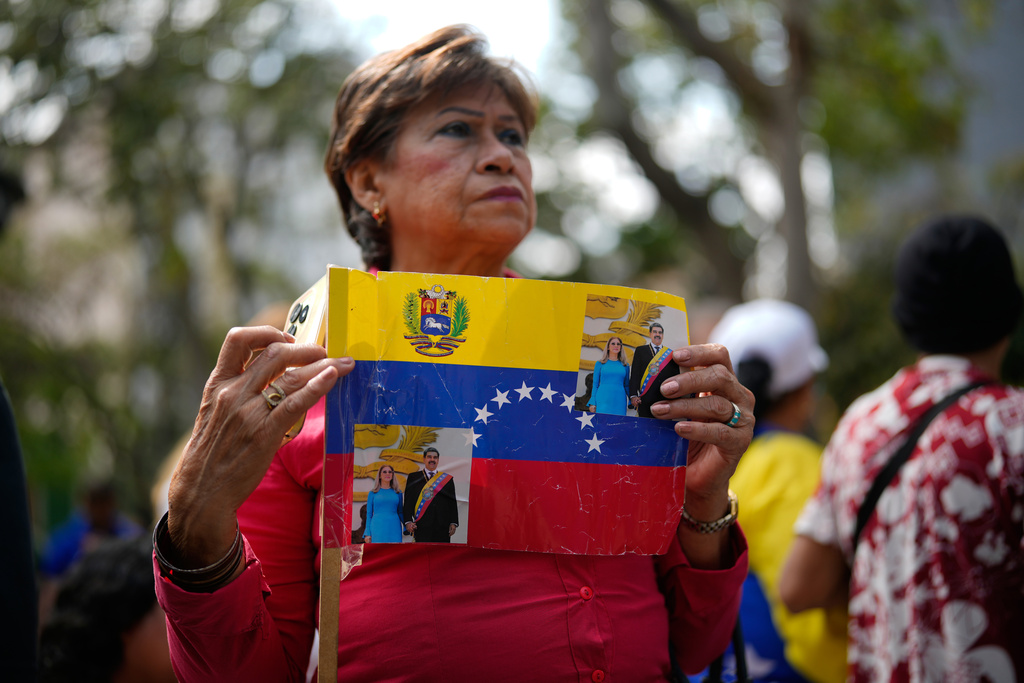 A woman attends a government-organized event to watch former President Nicolas Maduro and first lady Cilia Flores appear in a New York court on a screen in Caracas, Venezuela, Thursday, March 26, 2026. (AP Photo/Ariana Cubillos)