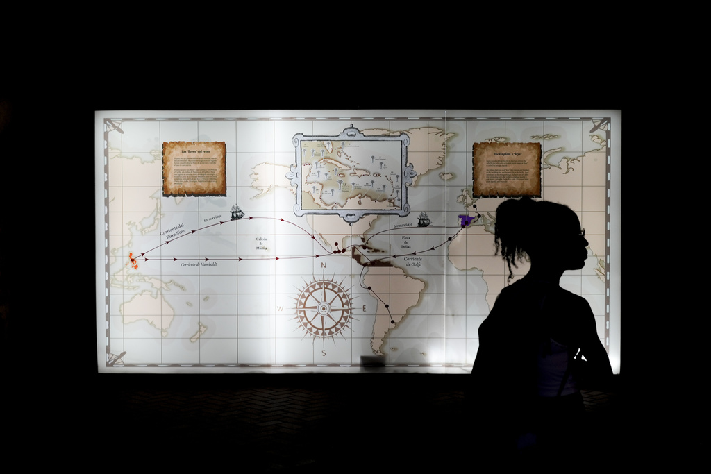 A tourist stands in front of a map outlining colonial interoceanic trade routes at the museum of Fort San Lorenzo, a 16th-century Spanish fortress that guarded the Caribbean entrance to the Chagres River, in Colon, Panama, Tuesday, Aug. 12, 2025. (AP Photo/Matias Delacroix)