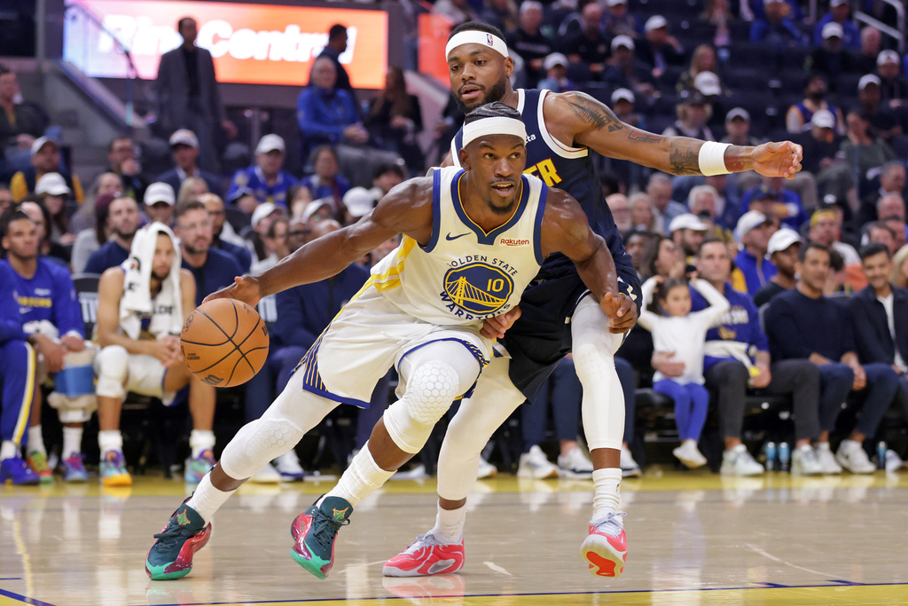 Golden State Warriors' Jimmy Butler III (10) drives past Denver Nuggets' Bruce Brown during the first half of an NBA basketball game in San Francisco on Thursday, Oct. 23, 2025. (Scott Strazzante/San Francisco Chronicle via AP)