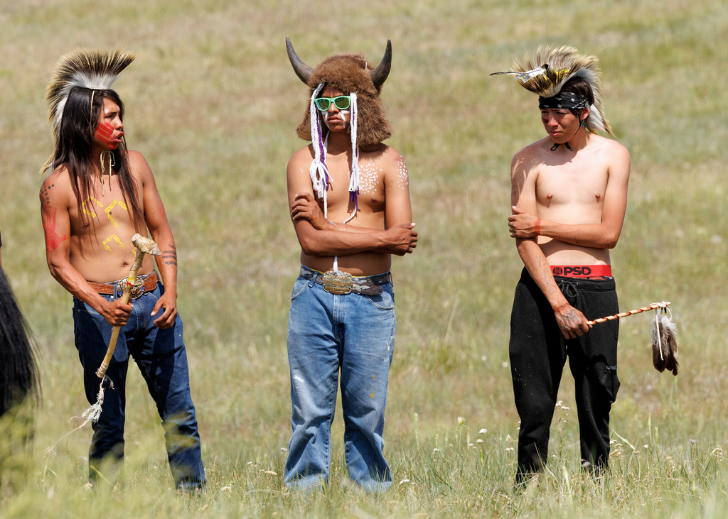 Joseph Fast, 22, Horse Austin Warrior, 19, and John Austin, 18, stand together after the riding in the horse charging event during festivities to commemorate the 150th anniversary of the Battle of the Little Bighorn in Crow Agency, Mont., on Thursday, June 25, 2026. (AP Photo/Tailyr Irvine)