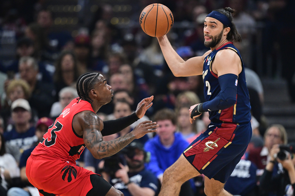 Cleveland Cavaliers guard Max Strus looks to pass whil being guarded by Toronto Raptors guard Jamal Shead during the first half in Game 1 of a first-round NBA playoffs basketball series, Saturday, April 18, 2026, In Cleveland. (AP Photo/David Dermer)