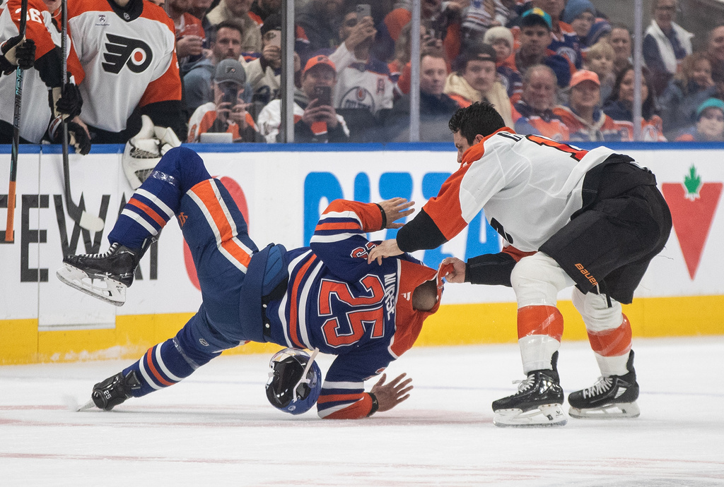 Philadelphia Flyers' Garnet Hathaway (19) and Edmonton Oilers' Darnell Nurse (25) fight during the first period of an NHL hockey game, in Edmonton, Saturday, Jan. 3, 2026. (Jason Franson/The Canadian Press via AP)