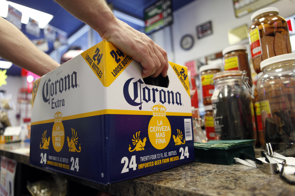 FILE - A customer places a case of Corona Extra on the checkout counter for purchase at Susquehanna Beer and Soda in Marysville, Pa, April 1, 2010. (AP Photo/Carolyn Kaster, File)