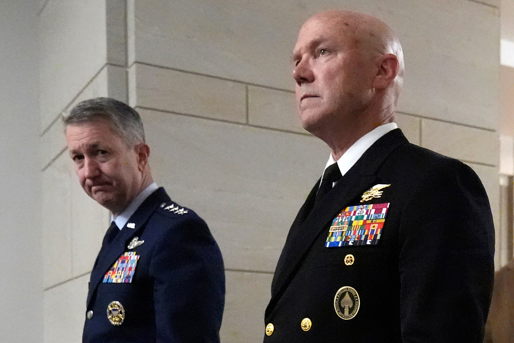 U.S. Navy Adm. Frank M. Bradley, right, accompanied by Gen. Dan Caine, chairman of the Joint Chiefs of Staff, left, walks to a meeting with senators on Capitol Hill, Thursday, Dec. 4, 2025, in Washington. (AP Photo/Mark Schiefelbein)