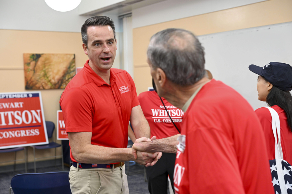 Republican candidate Stewart Whitson, left, who is running for the empty 11th congressional seat, greets supporters during a rally at the Kings Park Library, Saturday, Sept. 6, 2025 in Burke, Va. (AP Photo/Kevin Wolf)