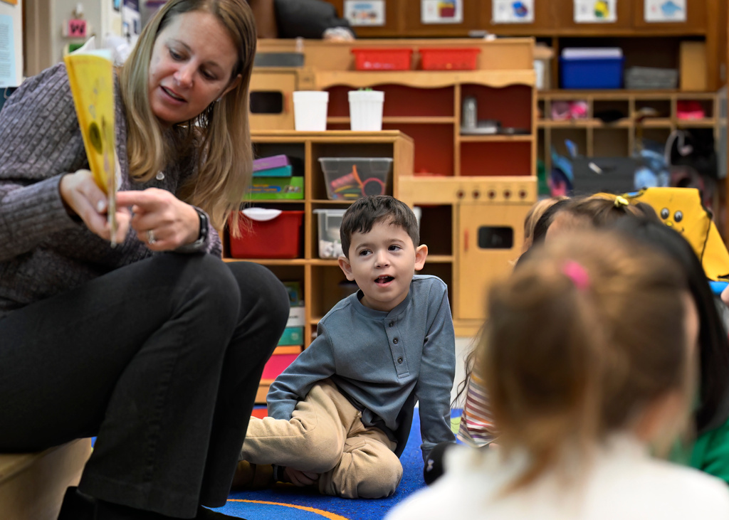 Students, including Isaac De Oliviera Matielo, center, listen as kindergarten teacher Christin Labriola, left, reads the book "Dumpling Soup" to her class, incorporating Asian American and Pacific Islander subjects in her class at Webster Hill Elementary School in West Hartford, Conn., on Dec. 2, 2025. (AP Photo/Jessica Hill)