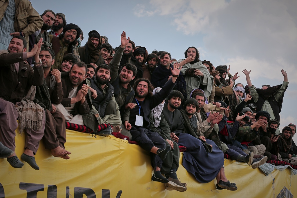Afghan men cheer as they attend the final of Afghanistan's annual buzkashi tournament, a traditional equestrian sport in which riders compete to score points using a fake goat carcass, on the outskirts of Kabul, Afghanistan, Monday, Dec. 22, 2025. (AP Photo)