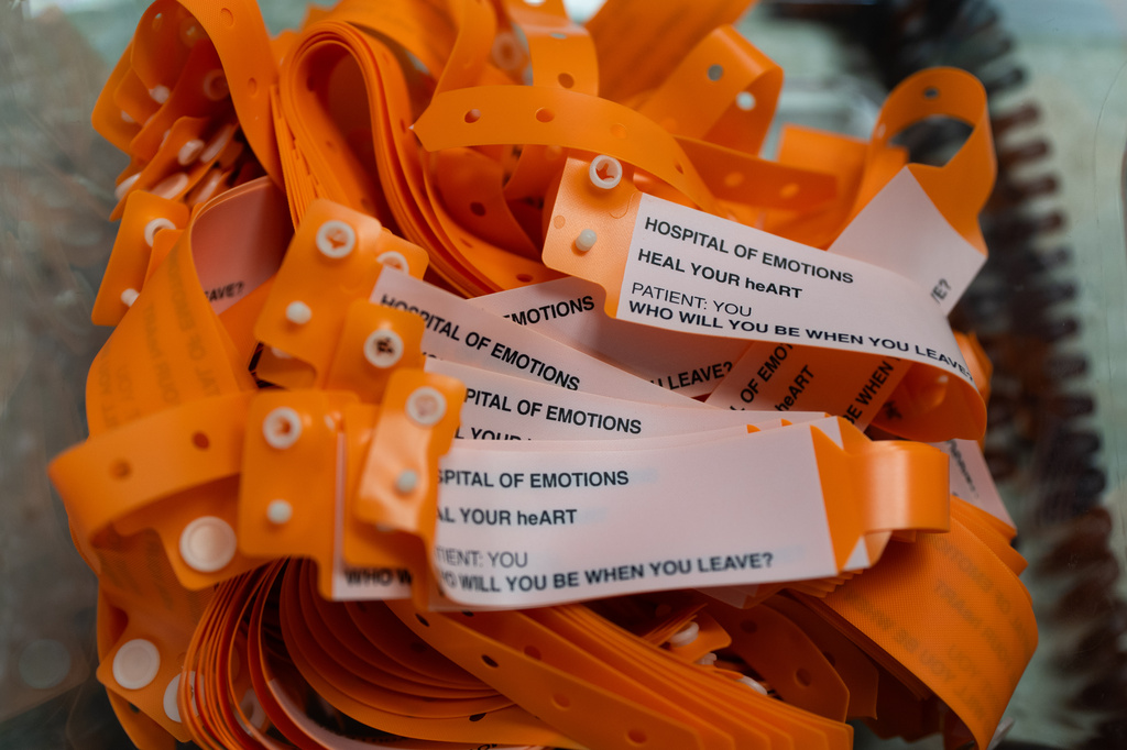 Neon-orange patient wristbands for visitors are displayed during the "Hospital of Emotions" exhibition inside a former hospital building in Los Angeles, Wednesday, July 22, 2026. (AP Photo/Jae C. Hong)