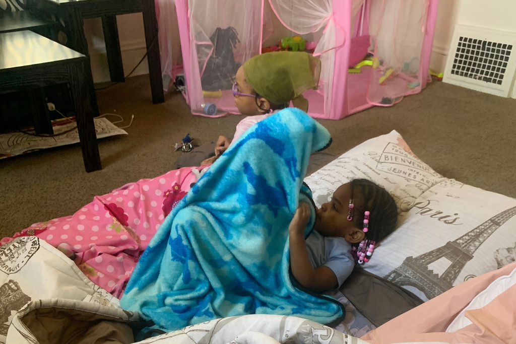 This photo provided by DeShaun Chatman shows Amor Wilson, left, and her half-sister Mila Chatman, in a living room fort in Cleveland on March 5, 2020. (DeShaun Chatman via AP)