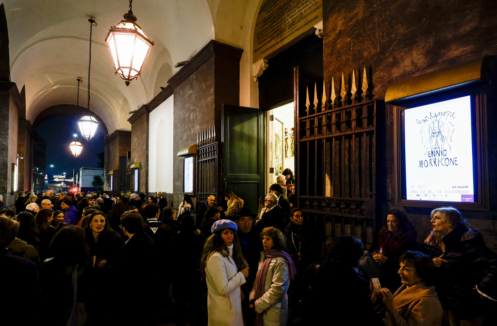 People queue at the San Carlo Theatre, in Naples, Italy, to attend at the general rehearsal of Ennio Morricone's only opera, Partenope, Thursday, Dec. 11, 2025. (AP Photo/Salvatore Laporta)