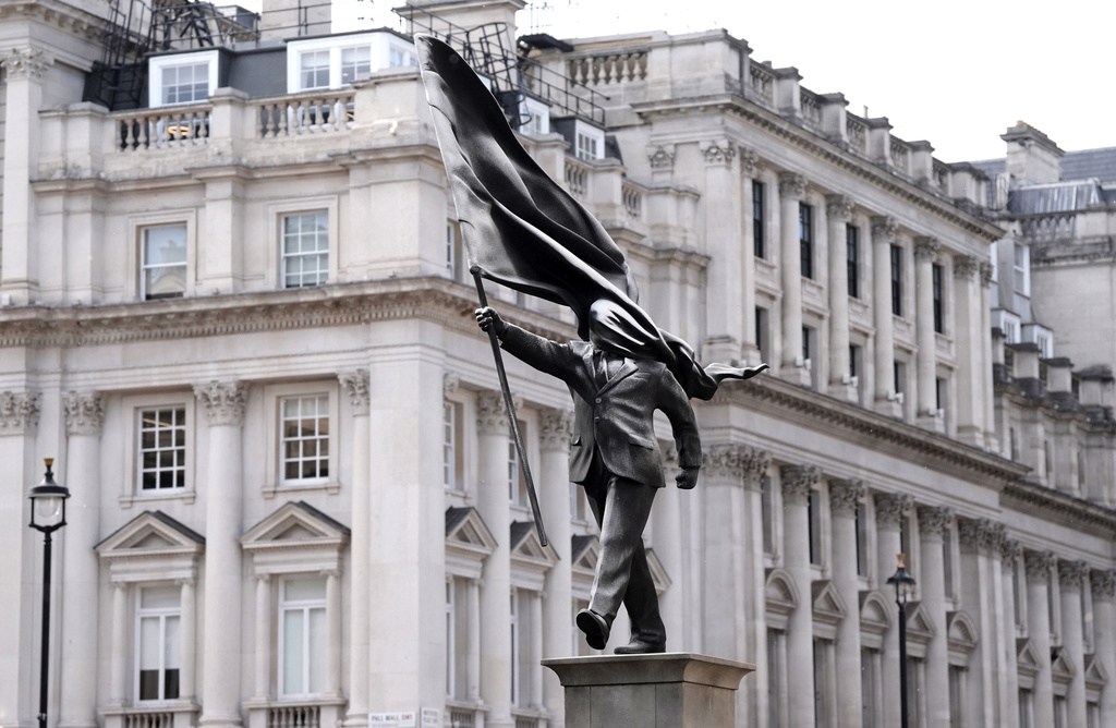 A statue of a man holding a flag which covers their face, and signed 'Banksy', has appeared in Waterloo Place in London. (Stefan Rousseau/PA via AP)