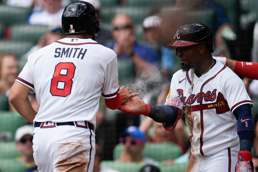 Atlanta Braves' Dominic Smith and Ozzie Albies, from left, celebrate scoring off the bat of Atlanta Braves' Drake Baldwin in the second inning of a baseball game against the Athletics, Wednesday, April 1, 2026, in Atlanta. (AP Photo/Mike Stewart)