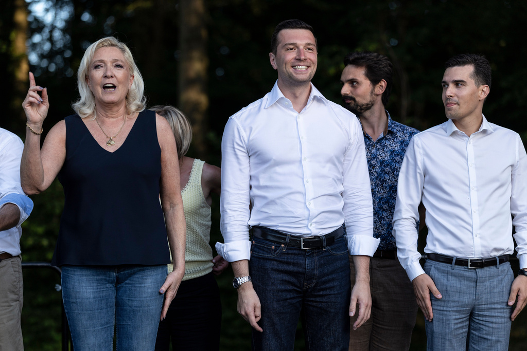Far-right leader Marine Le Pen, left, accompanied by far-right party National Rally president Jordan Bardella, center, speaks during a rally in Lievin, northern France, Saturday, July 4, 2026. (AP Photo/Jean-Francois Badias)