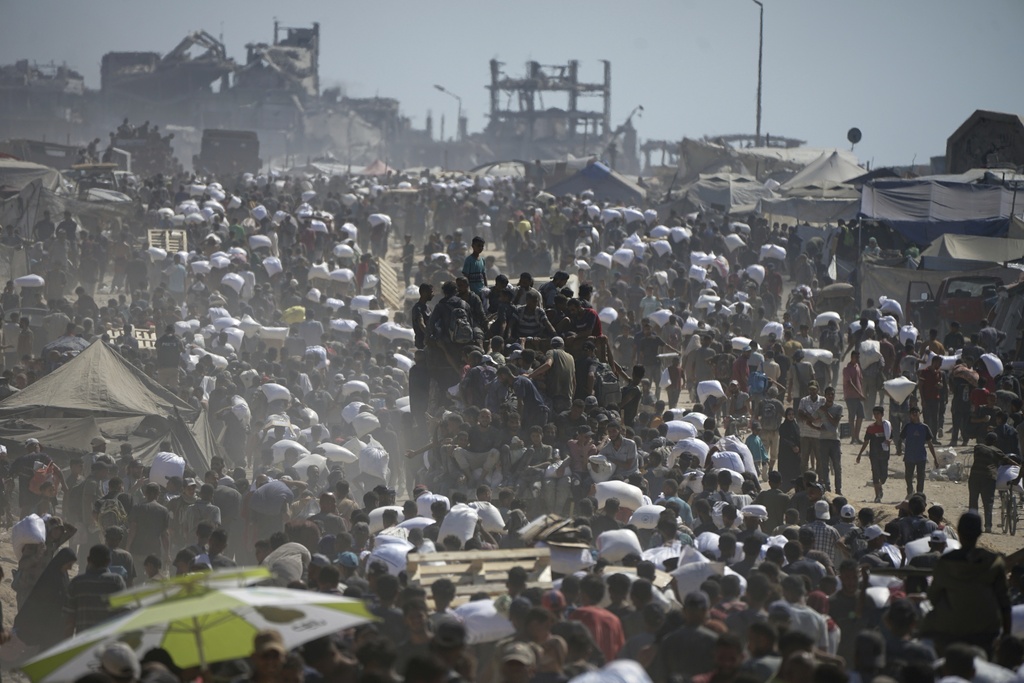 FILE - Palestinians carry sacks of flour taken from a humanitarian aid convoy en route to Gaza City, on the outskirts of Beit Lahiya, northern Gaza Strip, Friday, Aug. 1, 2025. (AP Photo/Jehad Alshrafi, File)