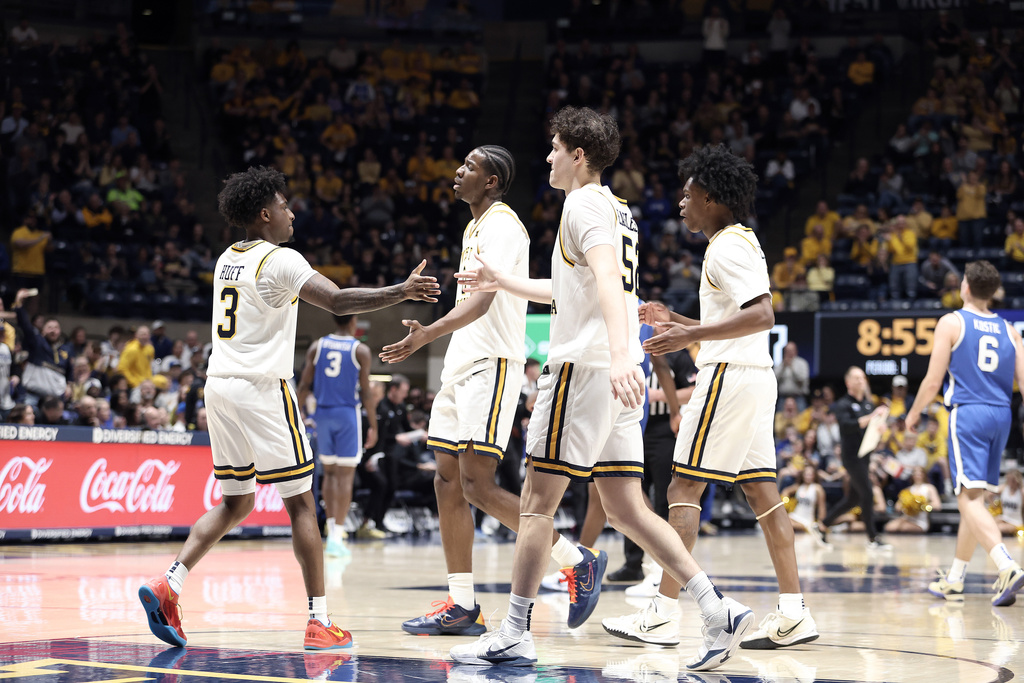 West Virginia players celebrate after scoring against BYU during the first half of an NCAA college basketball game Saturday, Feb. 28, 2026, in Morgantown, W.Va. (AP Photo/Kathleen Batten)