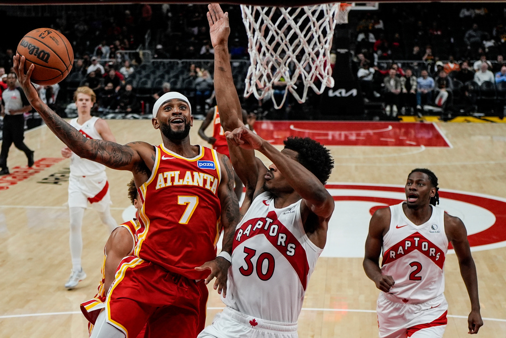 Atlanta Hawks guard Nickeil Alexander-Walker (7) shoots against Toronto Raptors guard Ochai Agbaji (30) during the second half of an NBA basketball game, Wednesday, Oct. 22, 2025, in Atlanta. (AP Photo/Mike Stewart)