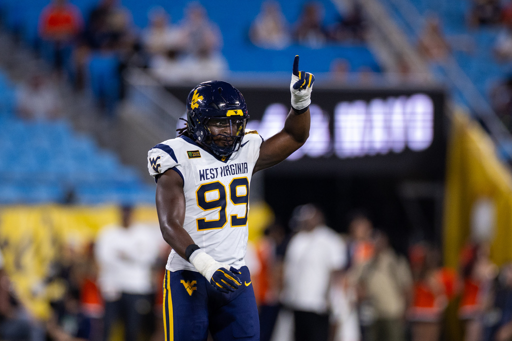 West Virginia defensive end David Afogho celebrates after a stop during the first half against Virginia in an NCAA college football game Saturday, Sept. 19, 2026, in Charlotte, N.C. (AP Photo/Scott Kinser)