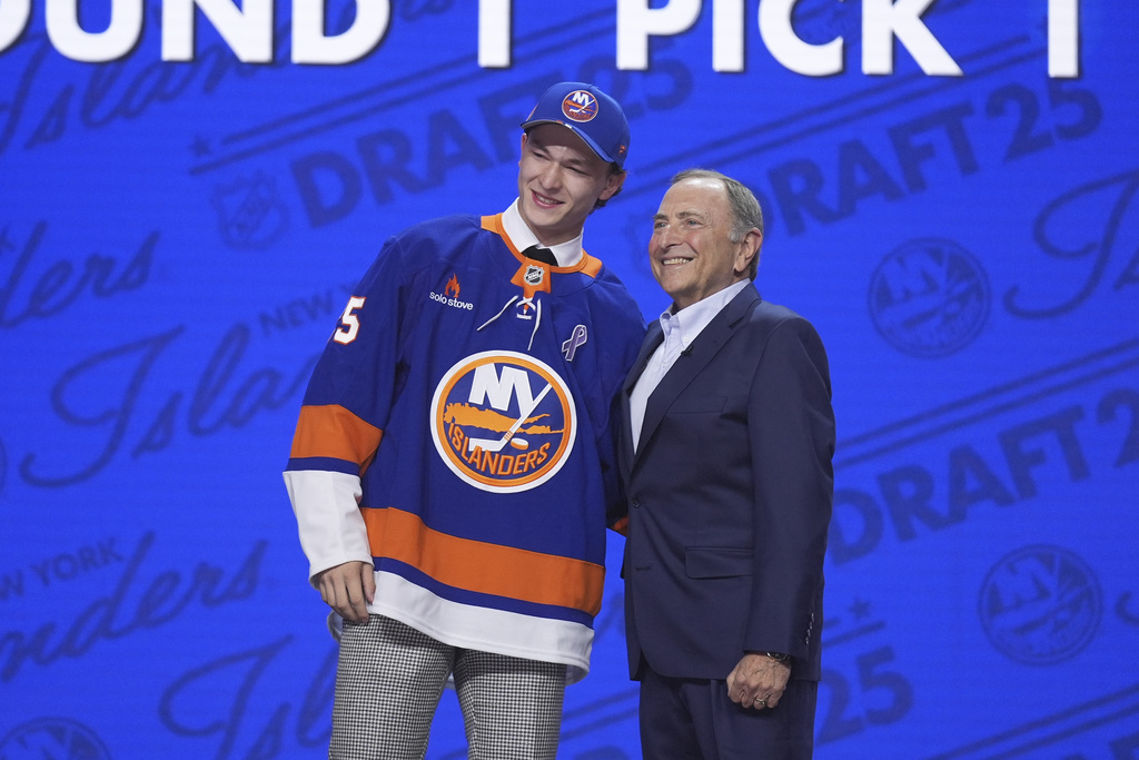 FILE - Matthew Schaefer, left, stands with NHL commissioner Gary Bettman after being drafted by the New York Islanders during the NHL hockey draft, June 27, 2025, in Los Angeles. (AP Photo/Damian Dovarganes, file)