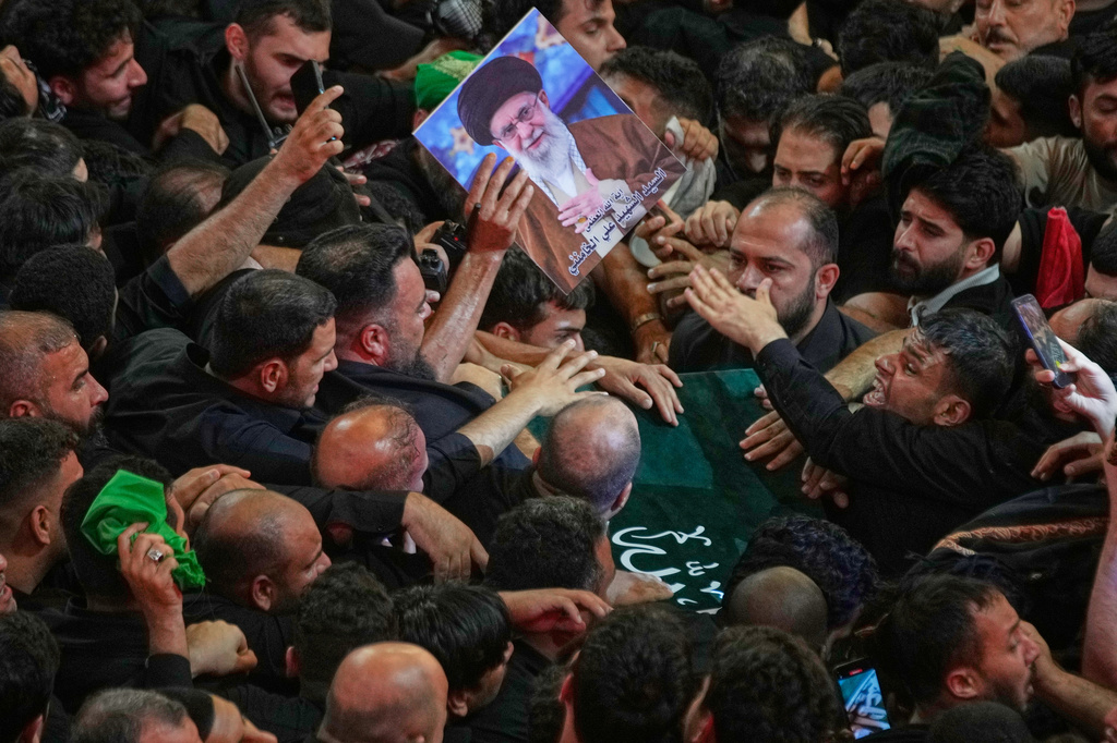 Mourners crowd around the coffin of the late Iranian Supreme Leader Ayatollah Ali Khamenei, reaching out to touch and support it as it moves through the crowd outside the Imam Hussein Shrine in Karbala, Iraq, early Thursday, July 9, 2026. (AP Photo/Khalil Hamra)